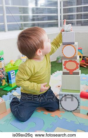 Baby boy stacking playing blocks at home View Large Photo Image Stock Photography - Baby boy stacking playing blocks at home. Fotosearch