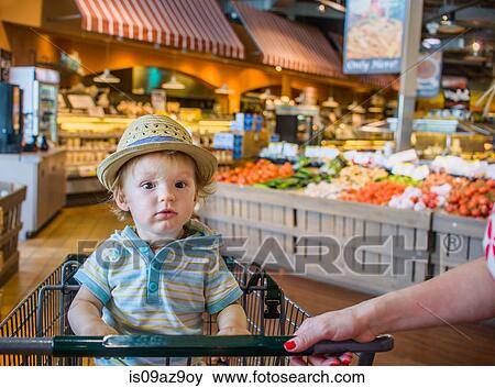 Baby boy wearing straw hat sitting in shopping trolley View Large Photo Image Stock Photo - Baby boy wearing straw hat sitting in shopping trolley. Fotosearch