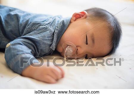 Baby boy with pacifier sleeping on bed View Large Photo Image Stock Photo - Baby boy with pacifier sleeping on bed. Fotosearch