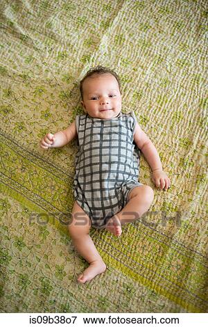 Stock Photo - Baby lying on bed. Fotosearch
