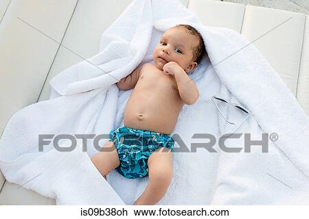 Stock Image - Baby lying on towel. Fotosearch