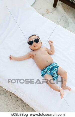 Baby with sunglasses lying on mattress View Large Photo Image Stock Image - Baby with sunglasses lying on mattress. Fotosearch