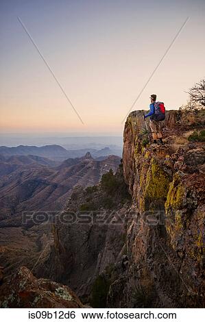 Backpacker looking out from ridge at dusk, Big Bend National Park, Texas, USA View Large Photo Image Stock Photograph - Backpacker looking out from ridge at dusk, Big Bend National Park, Texas, USA. Fotosearch