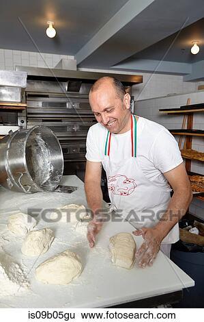 Baker in bakery, making bread View Large Photo Image Stock Photograph - Baker in bakery, making bread. Fotosearch
