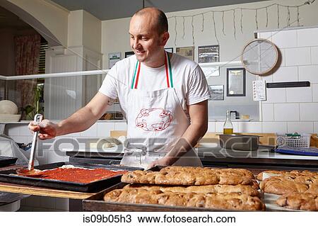 Stock Image - Baker working in bakery. Fotosearch