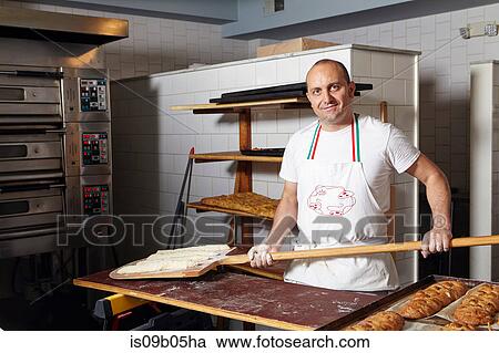 Baker working in bakery View Large Photo Image Stock Image - Baker working in bakery. Fotosearch