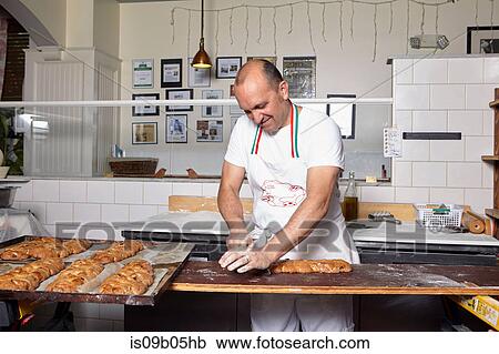 Baker working in bakery View Large Photo Image Stock Image - Baker working in bakery. Fotosearch