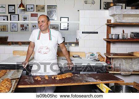 Baker working in bakery View Large Photo Image Stock Image - Baker working in bakery. Fotosearch