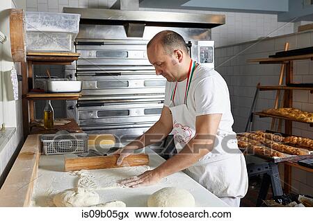 Stock Photo - Baker working in bakery. Fotosearch