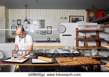 Baker working in bakery View Large Photo Image Stock Photo - Baker working in bakery. Fotosearch