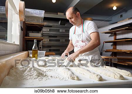 Baker working in bakery View Large Photo Image Stock Photo - Baker working in bakery. Fotosearch