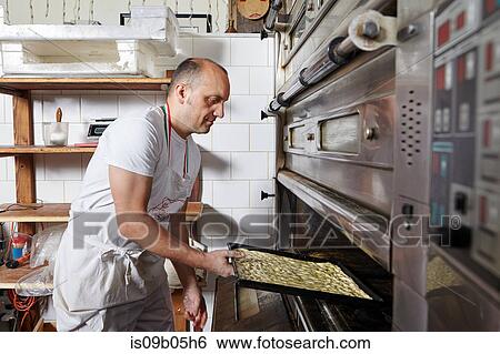 Stock Photograph - Baker working in bakery. Fotosearch