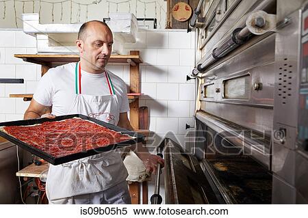 Stock Photography - Baker working in bakery. Fotosearch