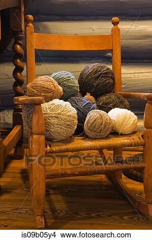Balls of wool on small old wooden rocking chair in bedroom of country cottage style residential log home, Quebec, Canada View Large Photo Image Picture - Balls of wool on small old wooden rocking chair in bedroom of country cottage style residential log home, Quebec, Canada. Fotosearch
