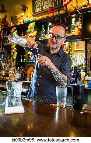 Barman preparing cocktail at public house counter View Large Photo Image Stock Photography - Barman preparing cocktail at public house counter. Fotosearch