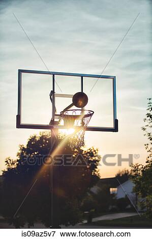 Basketball about to drop through basketball hoop View Large Photo Image Stock Photo - Basketball about to drop through basketball hoop. Fotosearch