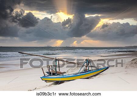 Beached fishing boat and dramatic sky at sunset, Taiba, Ceara, Brazil View Large Photo Image Stock Photography - Beached fishing boat and dramatic sky at sunset, Taiba, Ceara, Brazil. Fotosearch