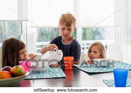 Big brother pouring milk into sisters plastic cup View Large Photo Image Stock Photography - Big brother pouring milk into sisters plastic cup. Fotosearch