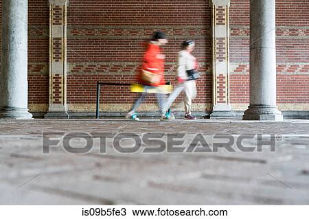 Blurred motion of people walking by brick wall, Amsterdam, Netherlands View Large Photo Image Stock Image - Blurred motion of people walking by brick wall, Amsterdam, Netherlands. Fotosearch