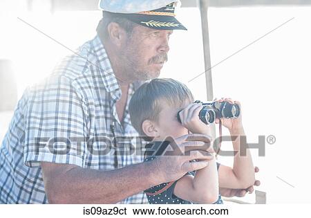 Boat captain with boy tourist looking through binoculars on boat trip, Cape Town, South Africa View Large Photo Image Stock Photograph - Boat captain with boy tourist looking through binoculars on boat trip, Cape Town, South Africa. Fotosearch