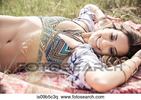 Boho style young woman in bikini top lying on picnic blanket View Large Photo Image Stock Photography - Boho style young woman in bikini top lying on picnic blanket. Fotosearch