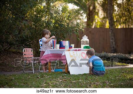 Stock Photography - Boy and sister preparing lemonade stand sign in garden. Fotosearch