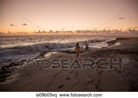 Boy and sister running on beach at sunrise, Blowing Rocks Preserve, Jupiter Island, Florida, USA View Large Photo Image Stock Photography - Boy and sister running on beach at sunrise, Blowing Rocks Preserve, Jupiter Island, Florida, USA. Fotosearch