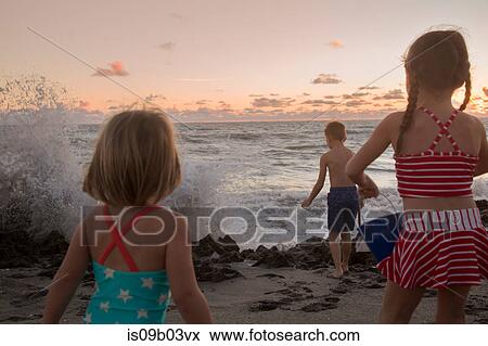 Boy and sisters watching splashing waves at sunrise, Blowing Rocks Preserve, Jupiter Island, Florida, USA View Large Photo Image Stock Photo - Boy and sisters watching splashing waves at sunrise, Blowing Rocks Preserve, Jupiter Island, Florida, USA. Fotosearch