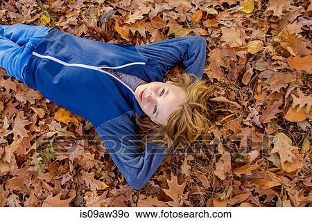 Boy lying in autumn leaves View Large Photo Image Picture - Boy lying in autumn leaves. Fotosearch