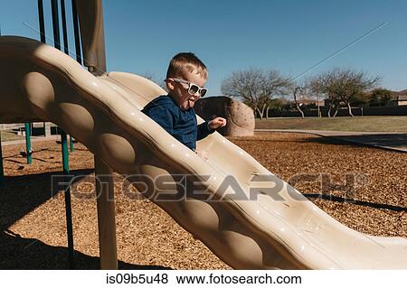 Boy on playground slide View Large Photo Image Stock Photo - Boy on playground slide. Fotosearch