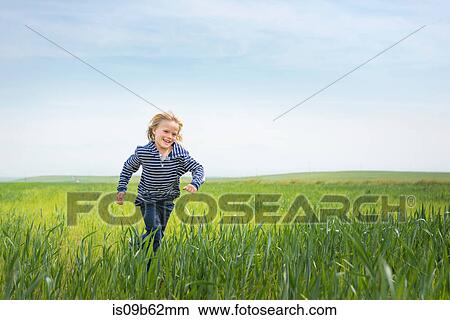 Picture - Boy running in grass. Fotosearch