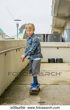 Boy skateboarding down parking lot ramp View Large Photo Image Stock Photography - Boy skateboarding down parking lot ramp. Fotosearch