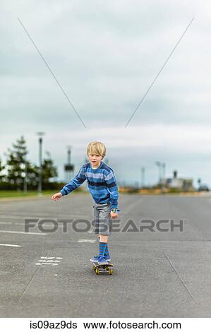 Boy skateboarding in parking lot View Large Photo Image Stock Photograph - Boy skateboarding in parking lot. Fotosearch