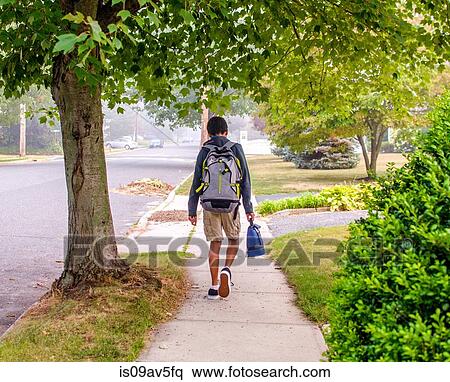 Boy with backpack walking on sidewalk View Large Photo Image Stock Photography - Boy with backpack walking on sidewalk. Fotosearch
