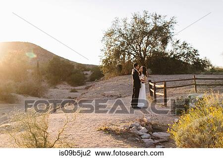 Bride and groom, in arid landscape, standing face to face View Large Photo Image Stock Image - Bride and groom, in arid landscape, standing face to face. Fotosearch
