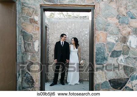 Bride and groom, outdoors, holding hands, smiling View Large Photo Image Stock Photograph - Bride and groom, outdoors, holding hands, smiling. Fotosearch