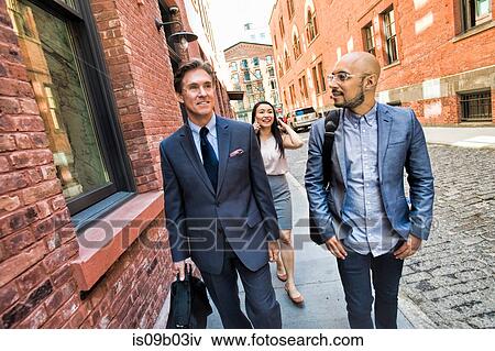 Business men and women walking together in street, smiling View Large Photo Image Stock Photo - Business men and women walking together in street, smiling. Fotosearch