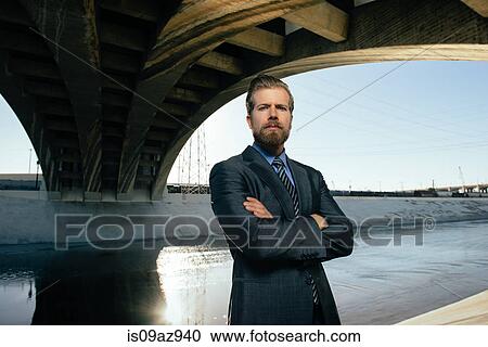 Businessman arms crossed looking at camera, Los Angeles river, California, USA View Large Photo Image Stock Image - Businessman arms crossed looking at camera, Los Angeles river, California, USA. Fotosearch