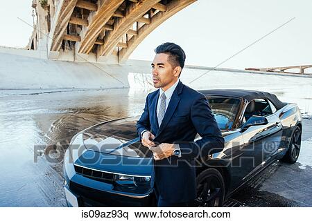 Businessman by car underneath bridge, Los Angeles river, California, USA View Large Photo Image Stock Photography - Businessman by car underneath bridge, Los Angeles river, California, USA. Fotosearch
