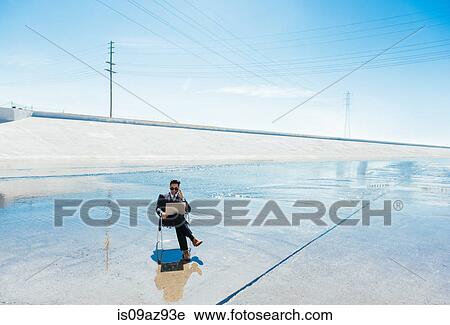 Businessman in deckchair on Los Angeles river using smartphone and laptop, California, USA View Large Photo Image Stock Image - Businessman in deckchair on Los Angeles river using smartphone and laptop, California, USA. Fotosearch