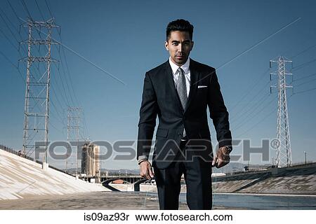 Stock Photography - Businessman looking at camera, Los Angeles river, California, USA. Fotosearch