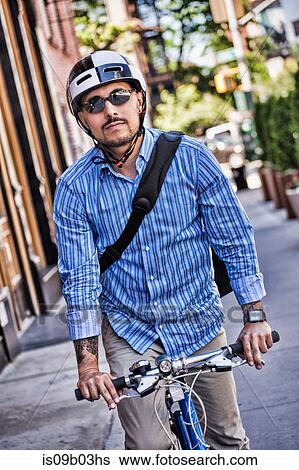 Stock Photograph - Businessman riding bike in street. Fotosearch