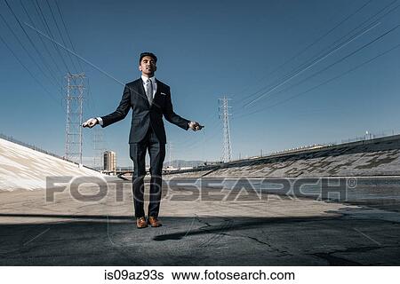 Businessman skipping, Los Angeles river, California, USA View Large Photo Image Stock Photograph - Businessman skipping, Los Angeles river, California, USA. Fotosearch