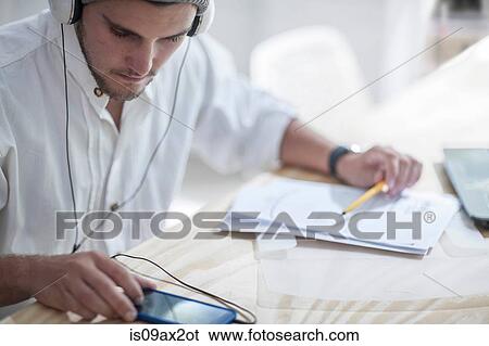 Businessman working while using smartphone in loft office View Large Photo Image Stock Photograph - Businessman working while using smartphone in loft office. Fotosearch