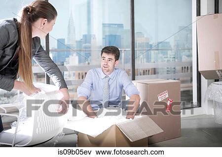 Businessmen and businesswoman unpacking in office View Large Photo Image Stock Photo - Businessmen and businesswoman unpacking in office. Fotosearch
