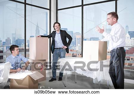 Businessmen and businesswoman unpacking in office View Large Photo Image Stock Photo - Businessmen and businesswoman unpacking in office. Fotosearch
