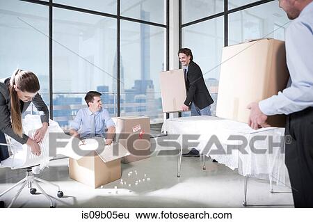 Businessmen and businesswoman unpacking in office View Large Photo Image Stock Photograph - Businessmen and businesswoman unpacking in office. Fotosearch