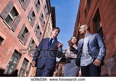 Businessmen and women walking outdoors, low angle view View Large Photo Image Stock Image - Businessmen and women walking outdoors, low angle view. Fotosearch