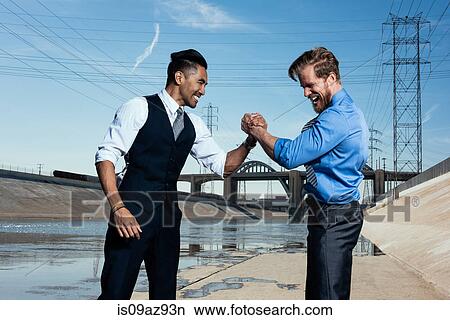 Businessmen arm wrestling, Los Angeles river, California, USA View Large Photo Image Picture - Businessmen arm wrestling, Los Angeles river, California, USA. Fotosearch