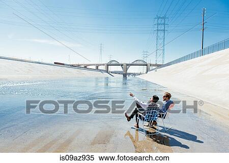 Businessmen sitting in deckchairs on Los Angeles river, California, USA View Large Photo Image Stock Photography - Businessmen sitting in deckchairs on Los Angeles river, California, USA. Fotosearch